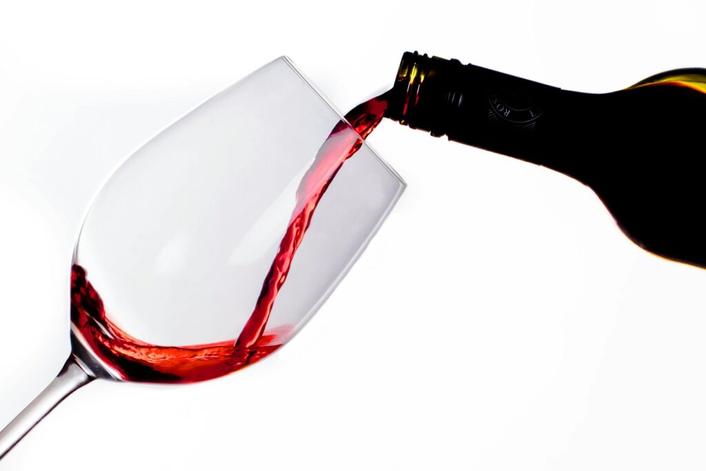 Homem segurando taça de vinho tinto com fundo desfocado, representando prevenção do câncer de próstata